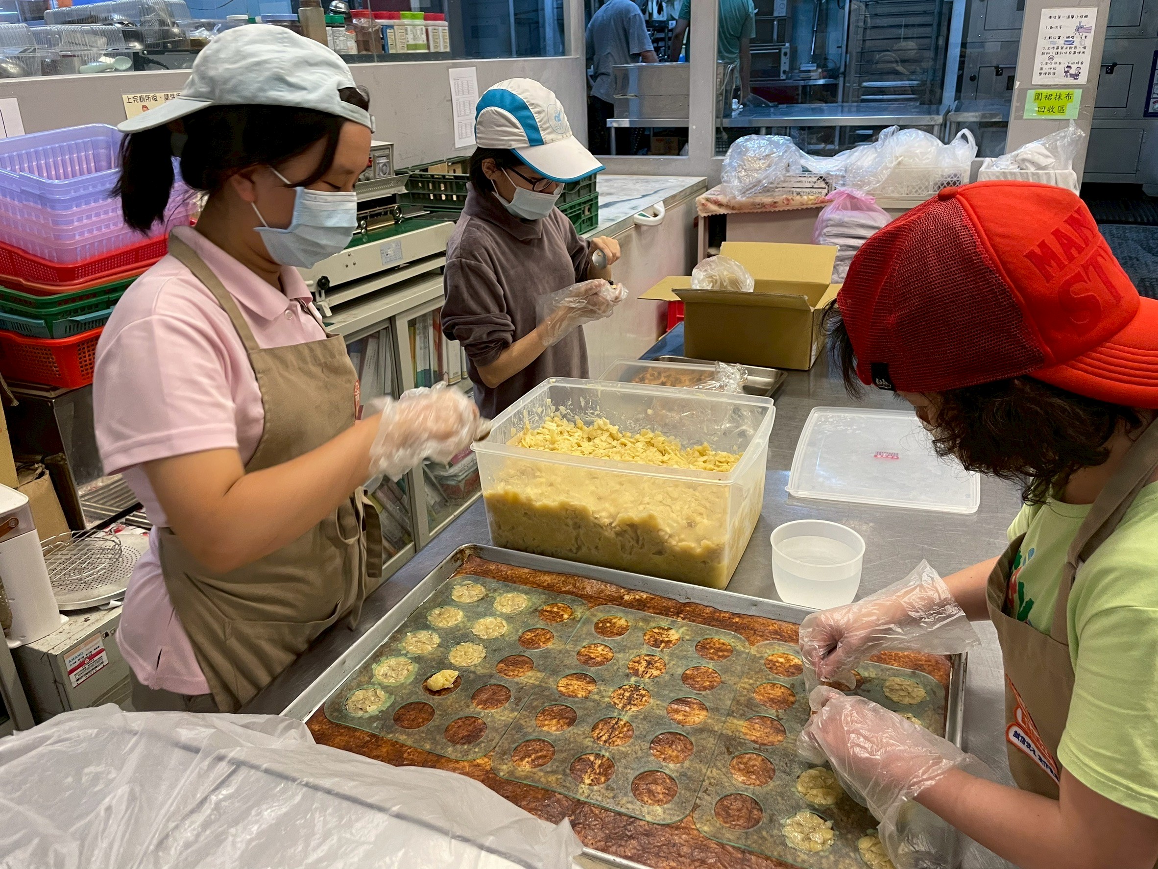員工用雙手一個個仔細捏，專注製作杏仁餅，要給顧客最用心的餅乾。(圖/糕菲庇護工場提供)