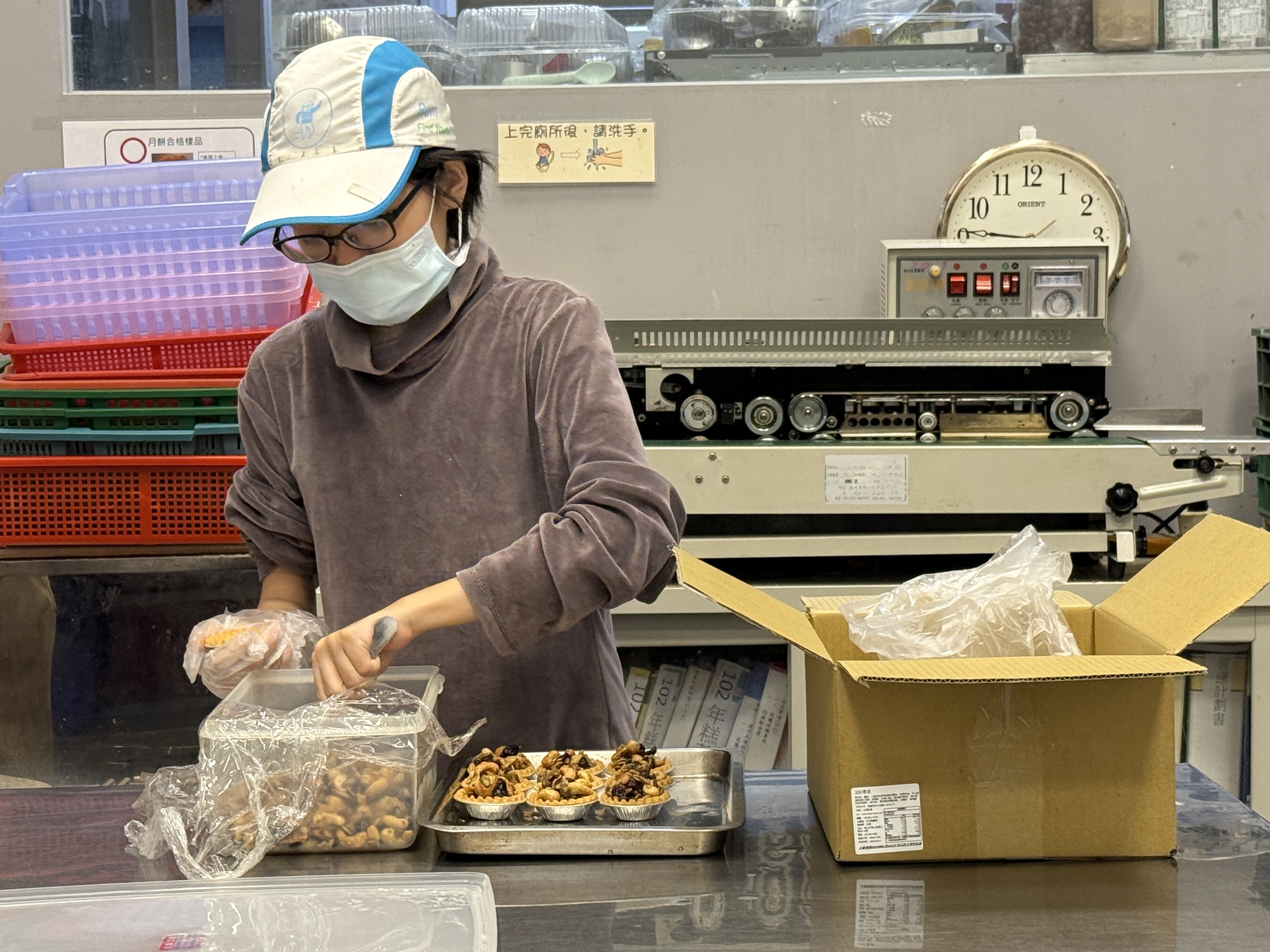 員工細心製作堅果塔，並仔細排列整齊。(圖/糕菲庇護工場提供)